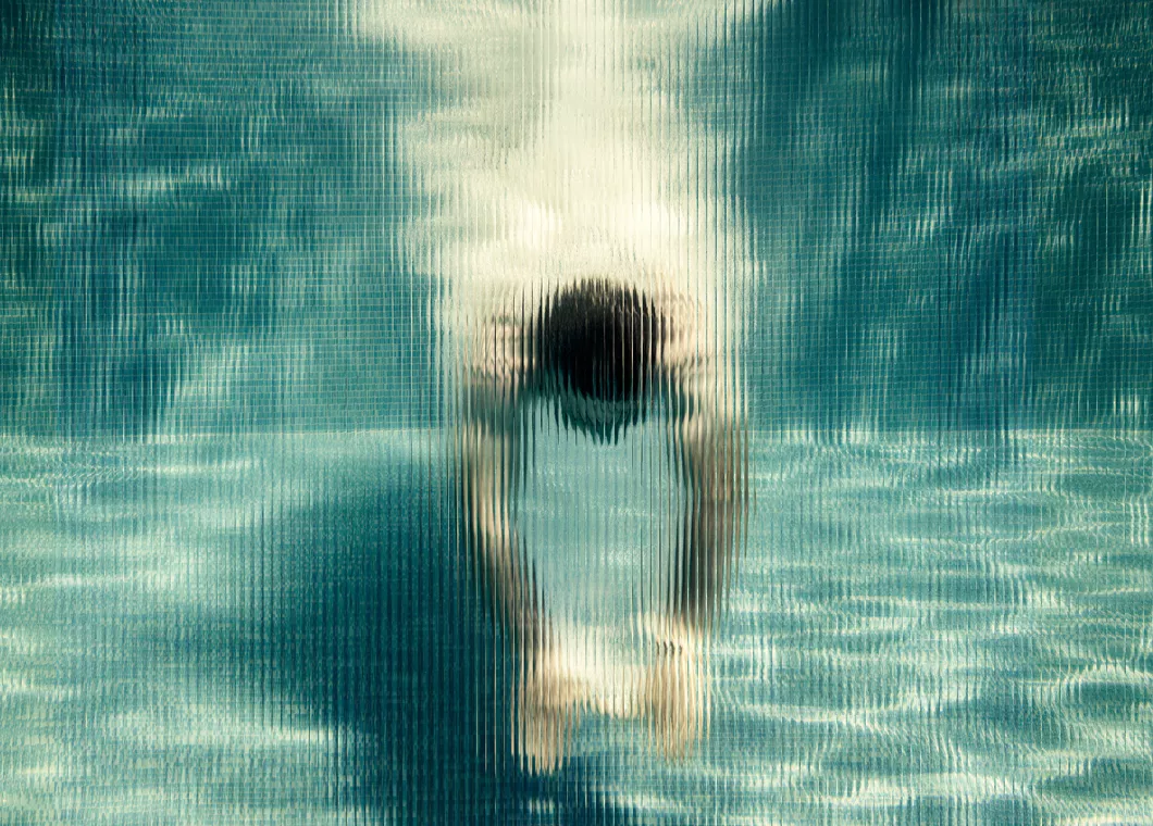 accent image, under water photo of a man diving into pool
